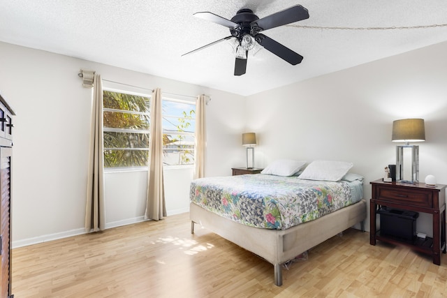 bedroom featuring ceiling fan, a textured ceiling, and light hardwood / wood-style flooring