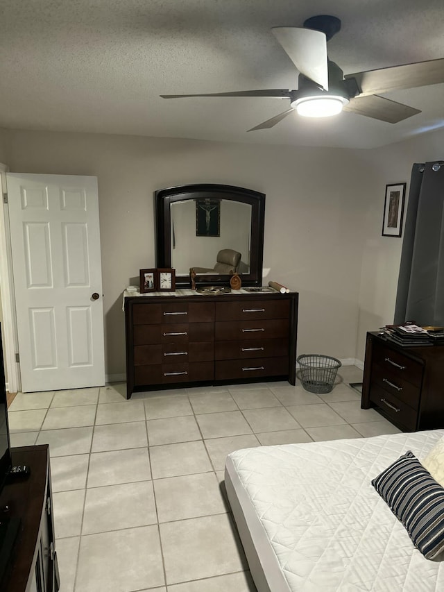 tiled bedroom with a textured ceiling and ceiling fan