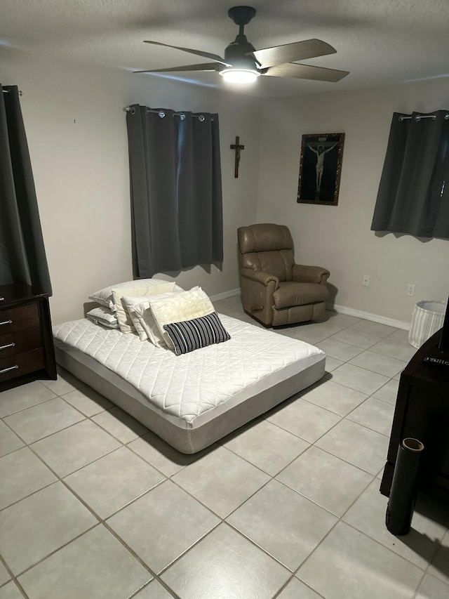 bedroom with light tile patterned flooring, a textured ceiling, and ceiling fan