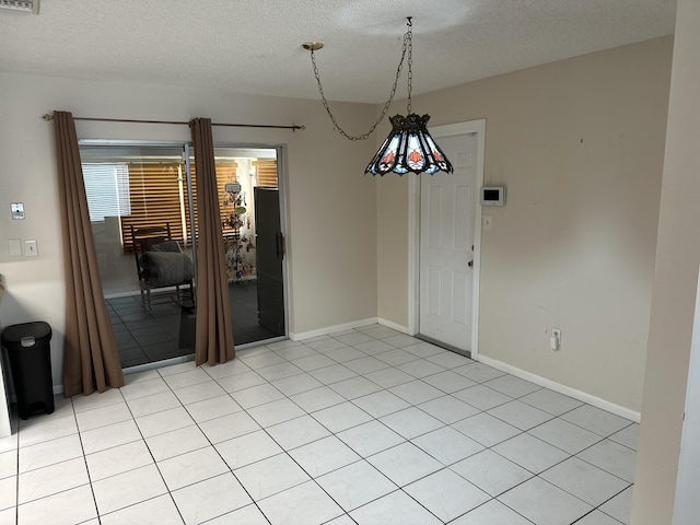 unfurnished dining area featuring a textured ceiling