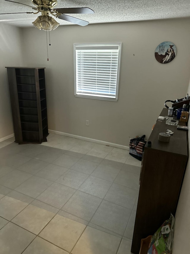 unfurnished bedroom with ceiling fan and a textured ceiling