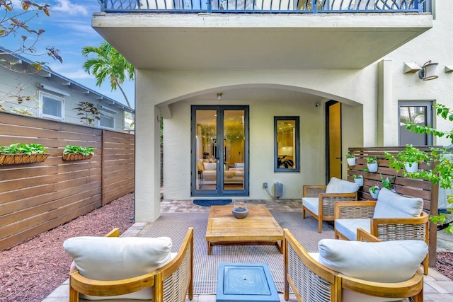 view of patio featuring an outdoor living space, french doors, and a balcony