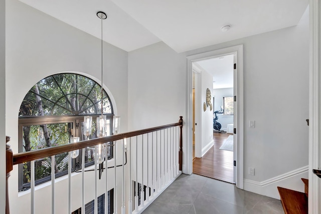 hallway featuring tile patterned flooring and a healthy amount of sunlight