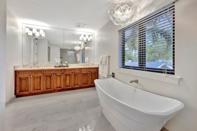 bathroom featuring vanity, a tub to relax in, and a notable chandelier