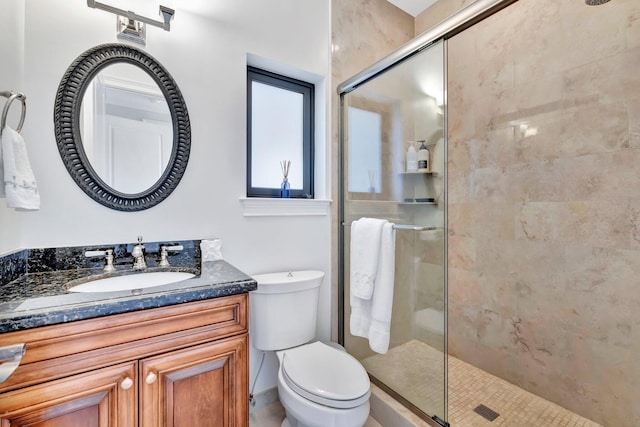 bathroom featuring vanity, toilet, and a shower with door