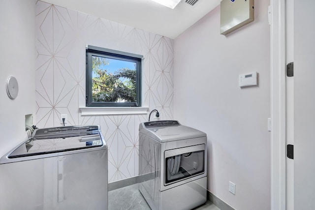 clothes washing area featuring separate washer and dryer