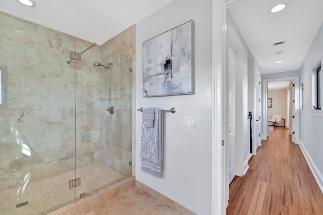 bathroom featuring hardwood / wood-style floors and a shower with shower door