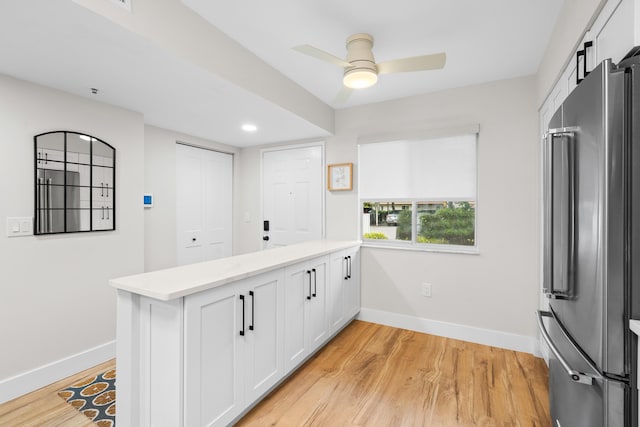 kitchen with high end fridge, kitchen peninsula, and white cabinets