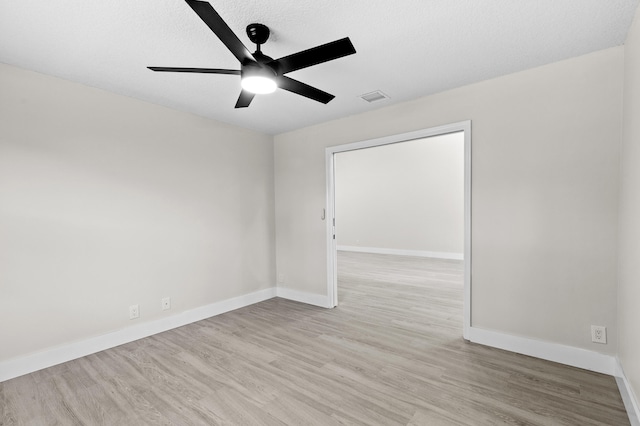 spare room featuring a textured ceiling, light hardwood / wood-style floors, and ceiling fan