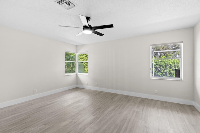 empty room featuring a textured ceiling, ceiling fan, and light wood-type flooring