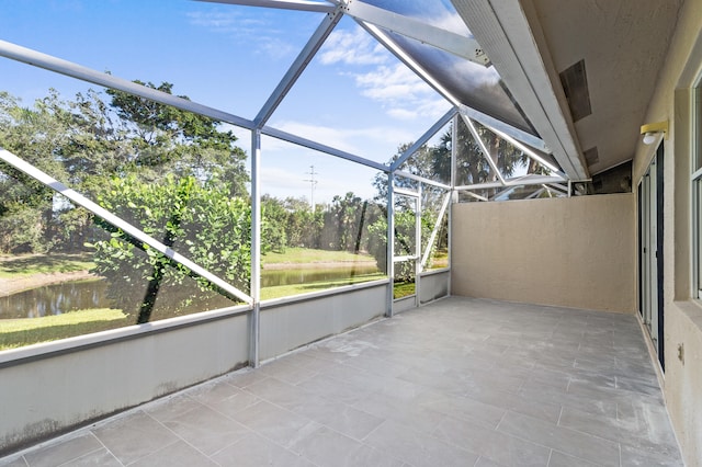 unfurnished sunroom featuring a water view