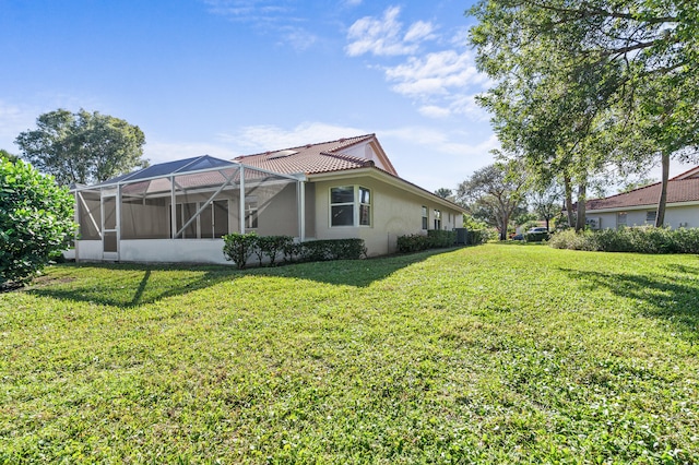 view of side of home featuring a lanai and a yard