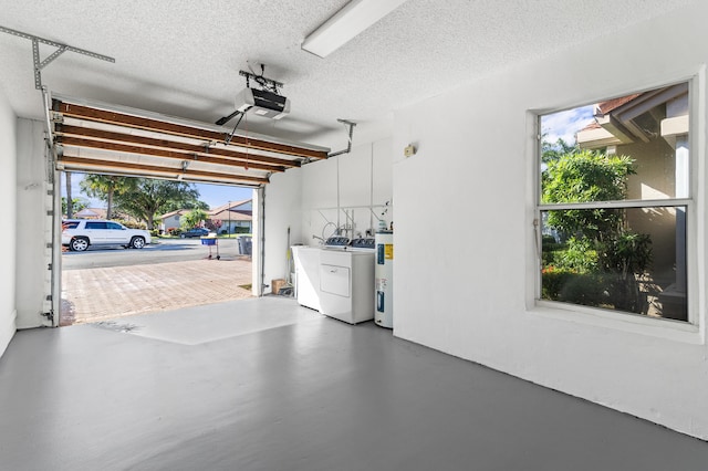 garage with a garage door opener, electric water heater, and washer and dryer