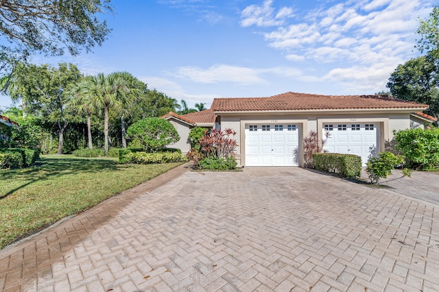 view of front of home with a garage and a front lawn