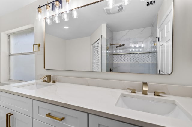 bathroom with tiled shower and vanity