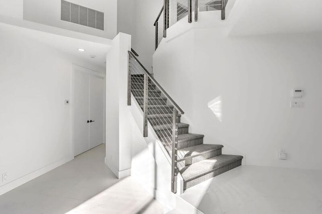 staircase with a towering ceiling