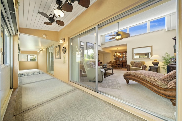 sunroom with lofted ceiling, ceiling fan with notable chandelier, and wooden ceiling