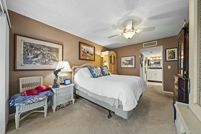 bedroom featuring connected bathroom, a textured ceiling, ceiling fan, and carpet flooring