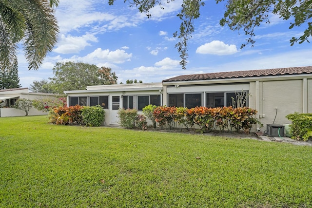 exterior space featuring a front yard and cooling unit