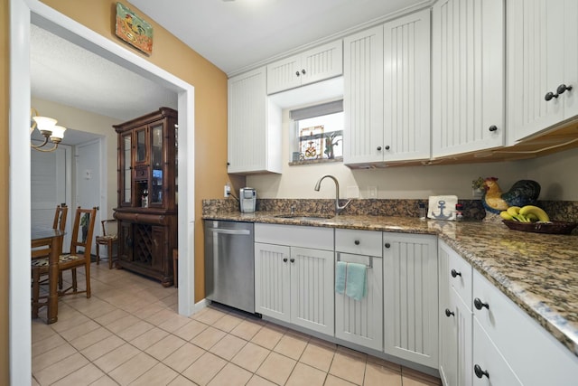 kitchen featuring sink, stone counters, white cabinets, light tile patterned flooring, and stainless steel dishwasher