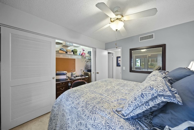 carpeted bedroom with ceiling fan and a textured ceiling