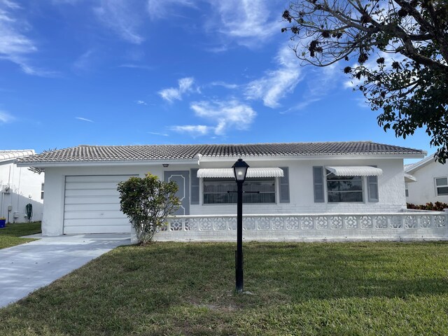 view of front of property featuring a garage and a front lawn