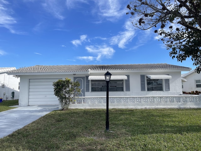 ranch-style home with a garage, stucco siding, a tile roof, and a front yard