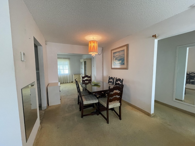 carpeted dining room featuring a textured ceiling