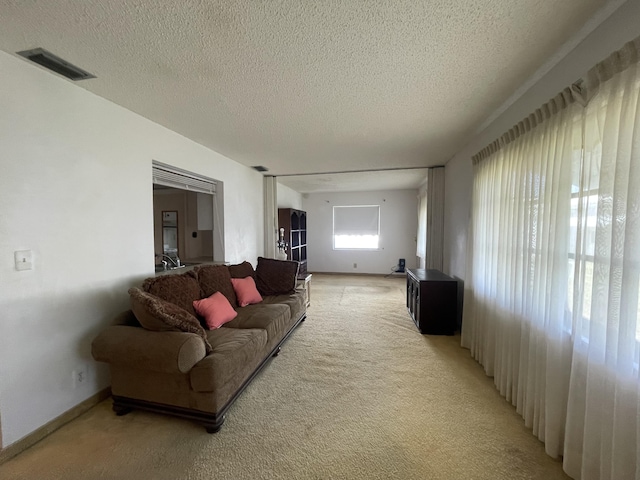 living room featuring light colored carpet and a textured ceiling