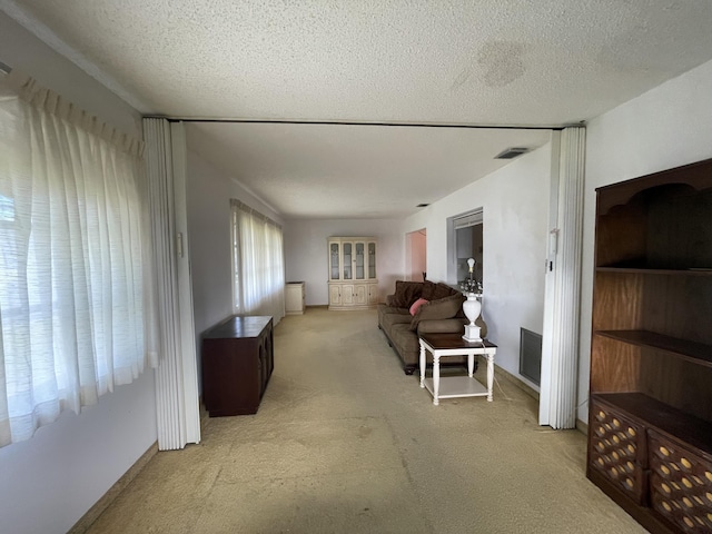 carpeted living room featuring a textured ceiling