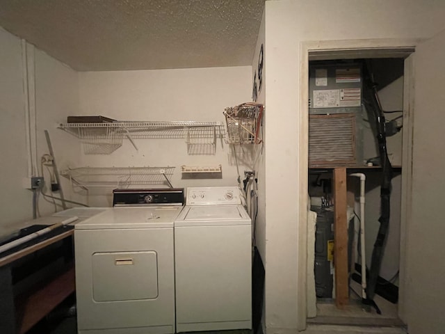 laundry room with washing machine and dryer and a textured ceiling