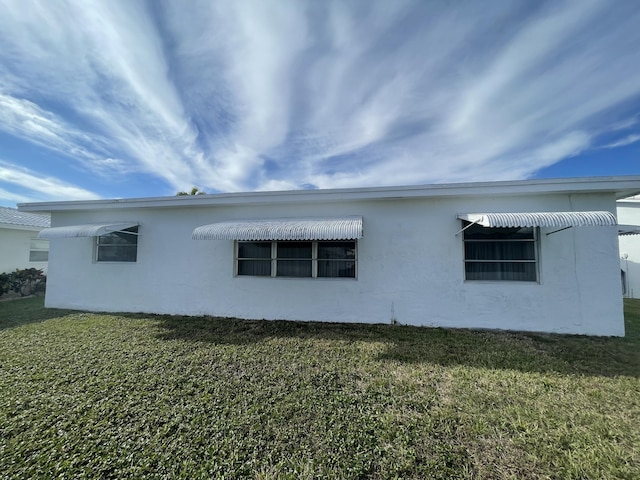 view of side of home with a lawn