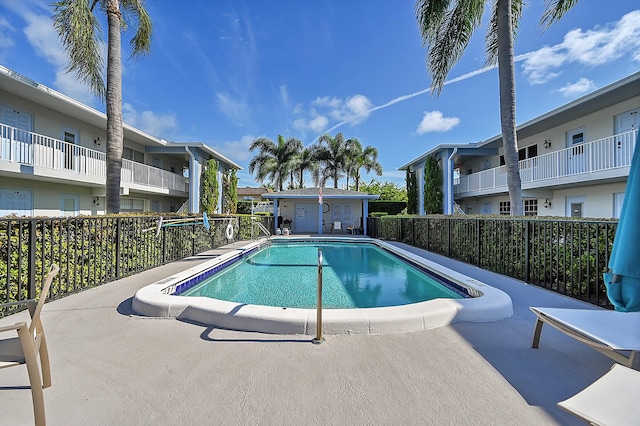 community pool with fence and a patio