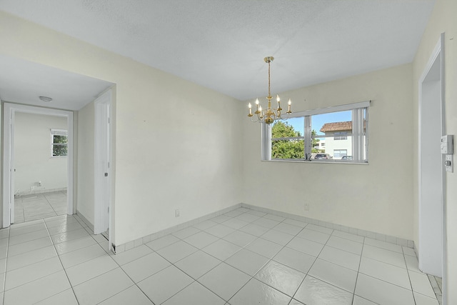 2110 NE 42nd St # 1B, Lighthouse Point, FL 33064 - empty room with a chandelier, light tile patterned flooring, and baseboards