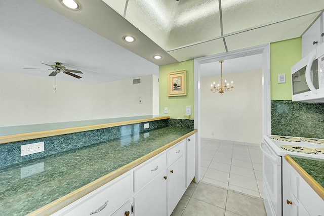 kitchen featuring white appliances, dark countertops, and white cabinets