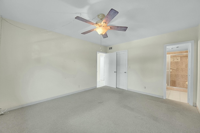 unfurnished bedroom featuring ensuite bath, a closet, carpet flooring, and baseboards