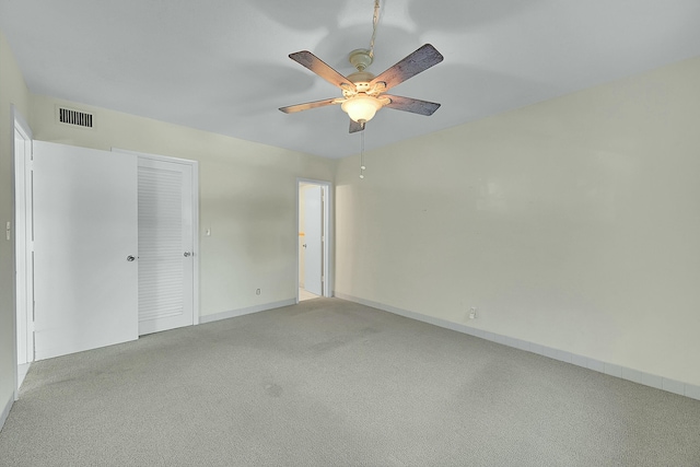 unfurnished bedroom with a ceiling fan, light colored carpet, visible vents, and baseboards