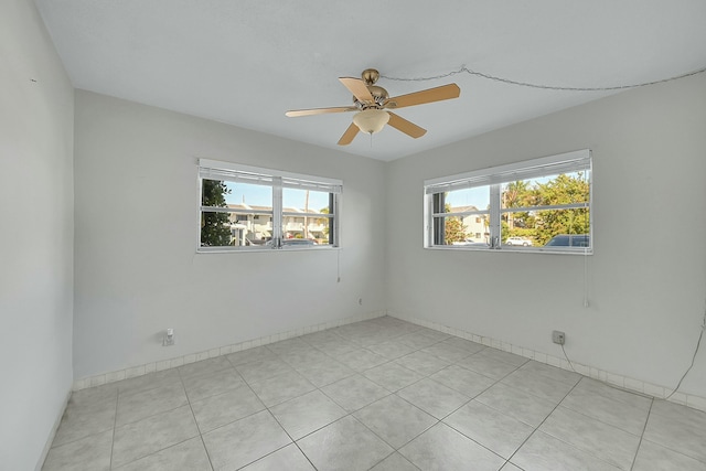 2110 NE 42nd St # 1B, Lighthouse Point, FL 33064 - empty room featuring ceiling fan, light tile patterned floors, and baseboards