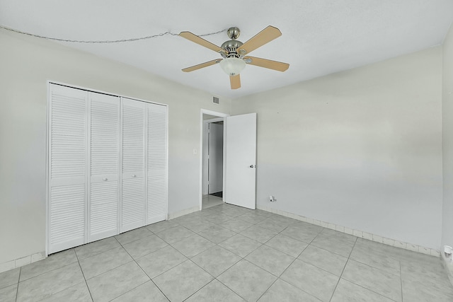 unfurnished bedroom with ceiling fan, light tile patterned floors, a closet, and visible vents