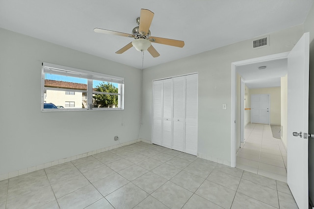 2110 NE 42nd St # 1B, Lighthouse Point, FL 33064 - unfurnished bedroom featuring light tile patterned flooring, a closet, and a ceiling fan
