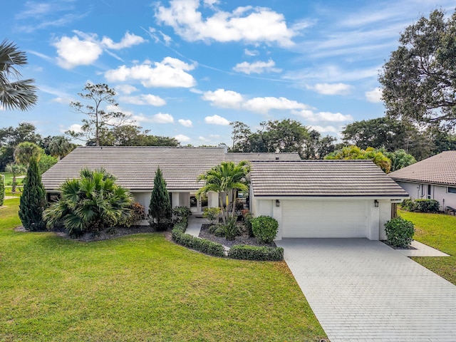 ranch-style house with a garage and a front lawn