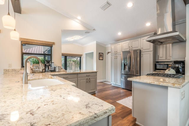 kitchen with sink, island range hood, vaulted ceiling, appliances with stainless steel finishes, and kitchen peninsula