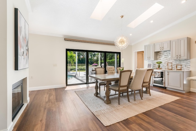 dining area with ornamental molding, wine cooler, a chandelier, and a skylight