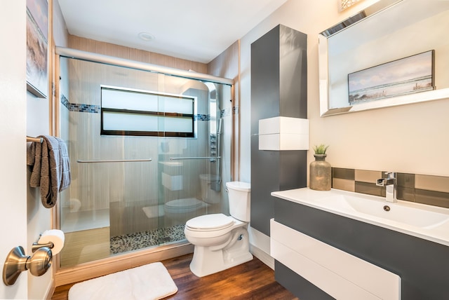 bathroom featuring walk in shower, vanity, toilet, and hardwood / wood-style floors