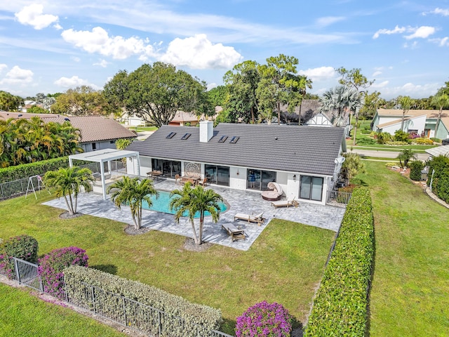 back of property with a fenced in pool, outdoor lounge area, a lawn, and a patio area