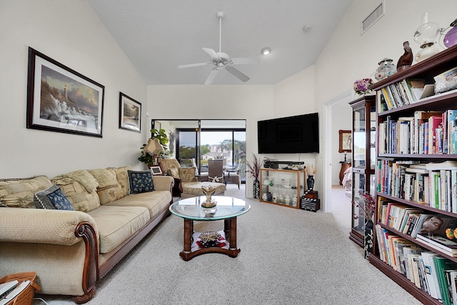 carpeted living room with ceiling fan and lofted ceiling