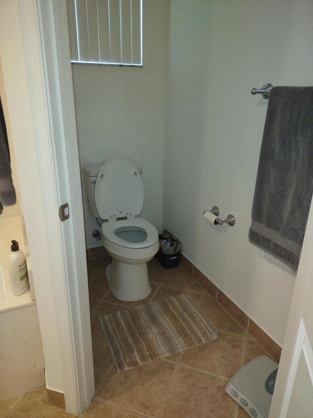 bathroom featuring baseboards, toilet, and tile patterned floors