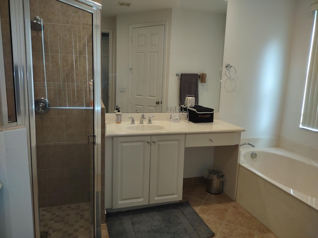 full bath with a stall shower, tile patterned flooring, a bath, and vanity