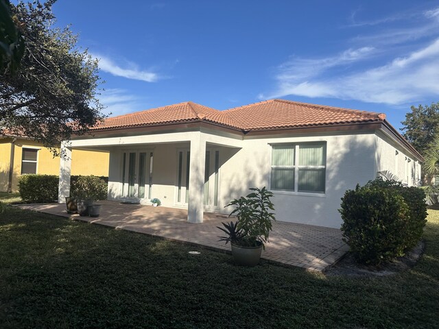 rear view of house with a yard and a patio