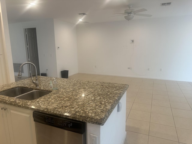 kitchen featuring dark stone counters, stainless steel dishwasher, a sink, and visible vents